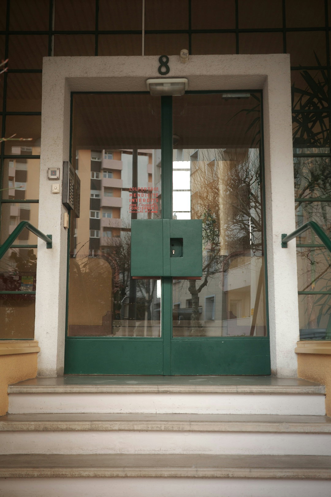 a-green-door-shows-the-building-s-entrance.jpg A green door shows the building's entrance